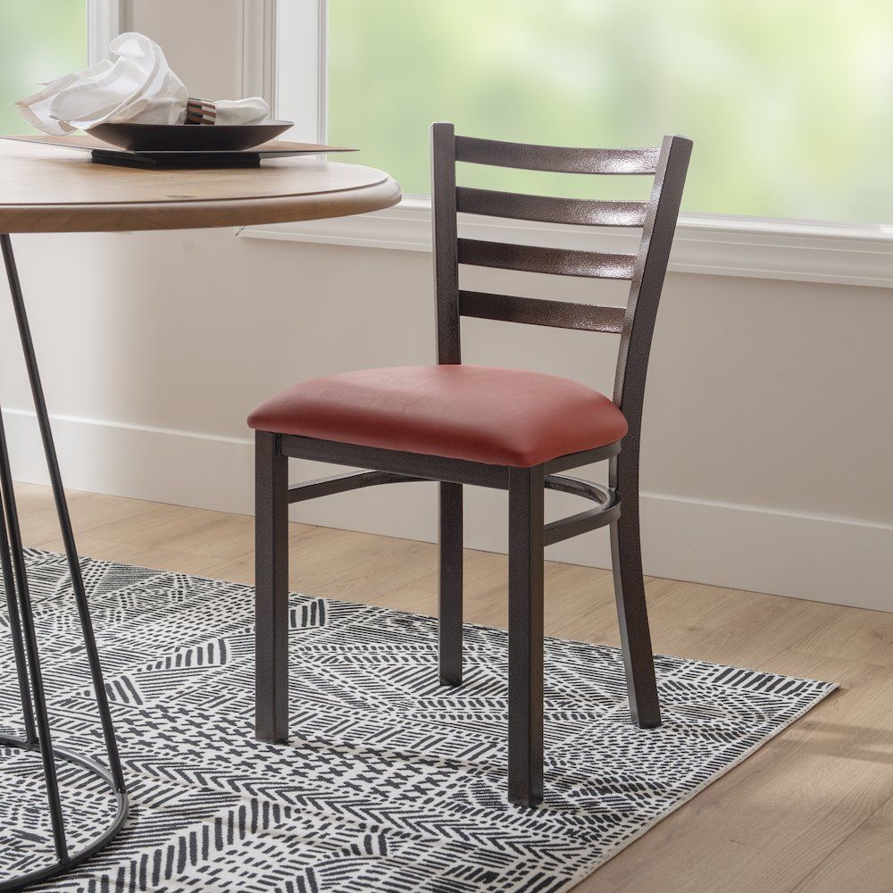 Set of two red Baxter metal side chairs by Start2Finish with sleek metal frames and cushioned seats.