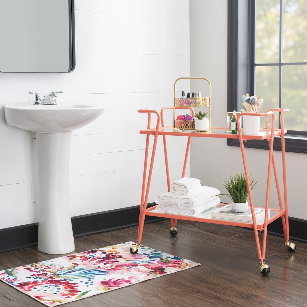 Coral mid-century bar cart by Start2Finish featuring a stylish wooden frame, two glass shelves, and brass accents.