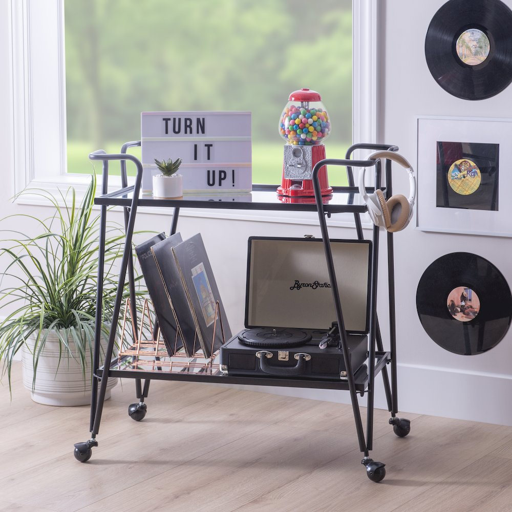 Black mid-century bar cart from Start2Finish with metal frame and wooden shelves, featuring wheels for mobility.