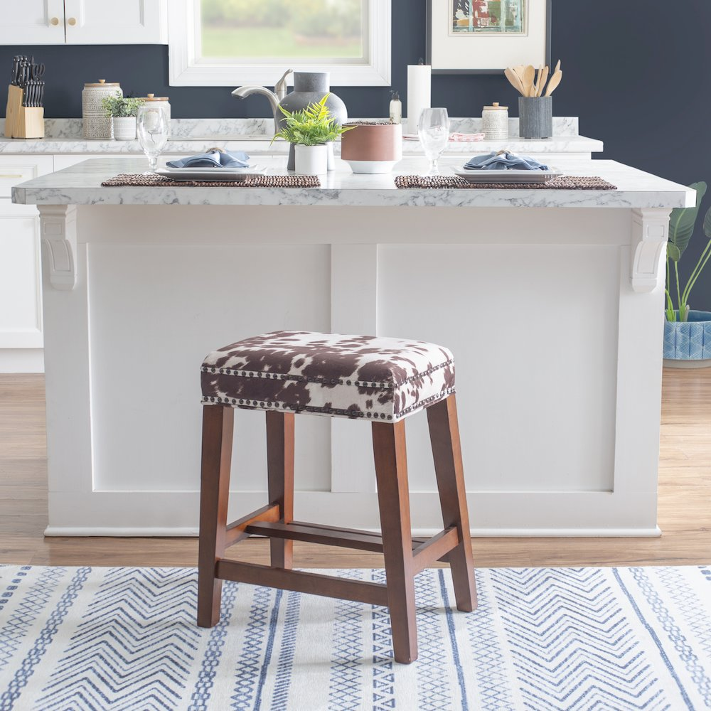 Walt Brown cow print counter stool by Start2Finish featuring a wooden frame and cow pattern upholstery for kitchen or bar area.