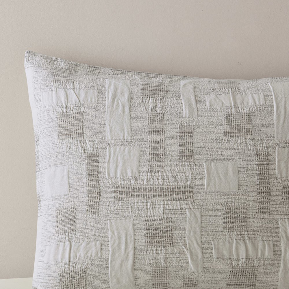 Cairo 3-piece cotton jacquard comforter set in ivory, featuring elegant woven patterns and matching pillow shams on a bed.