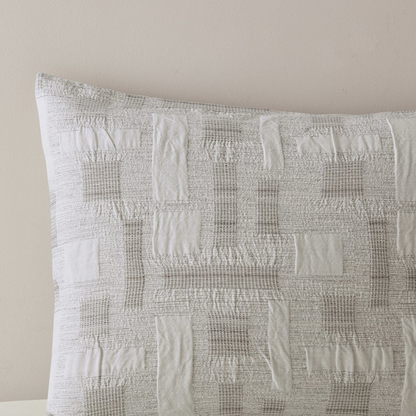 Cairo 3-piece cotton jacquard comforter set in ivory, featuring elegant woven patterns and matching pillow shams on a bed.