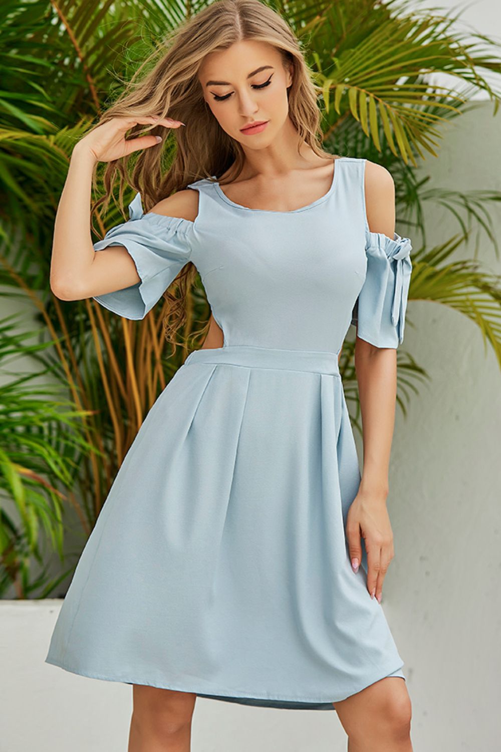 Pear Daisy cutout tied cold-shoulder dress with flowing fabric and stylish design, displayed on a mannequin.