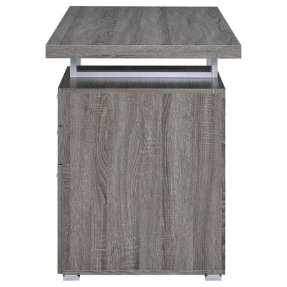 Weathered grey Brennan 47-inch office computer desk with three drawers by Start2Finish, shown from front with smooth surface and storage drawers.