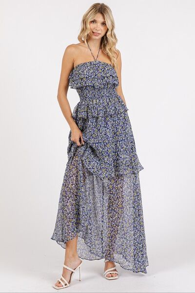 Jade Icarus Mittoshop ruffled floral smocked halter neck maxi dress worn by a woman, featuring a flowing design and vibrant floral pattern.