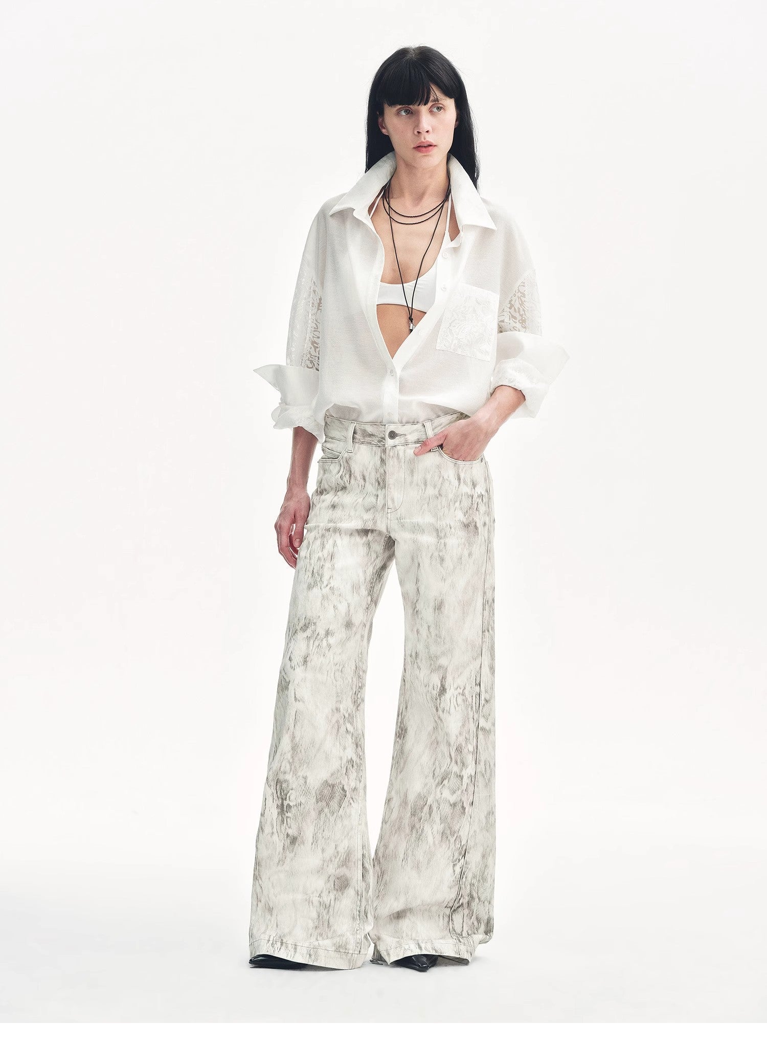 Brown Coeus "Phantom" snake print flared denim trousers with high waist and bold pattern, shown on a model.