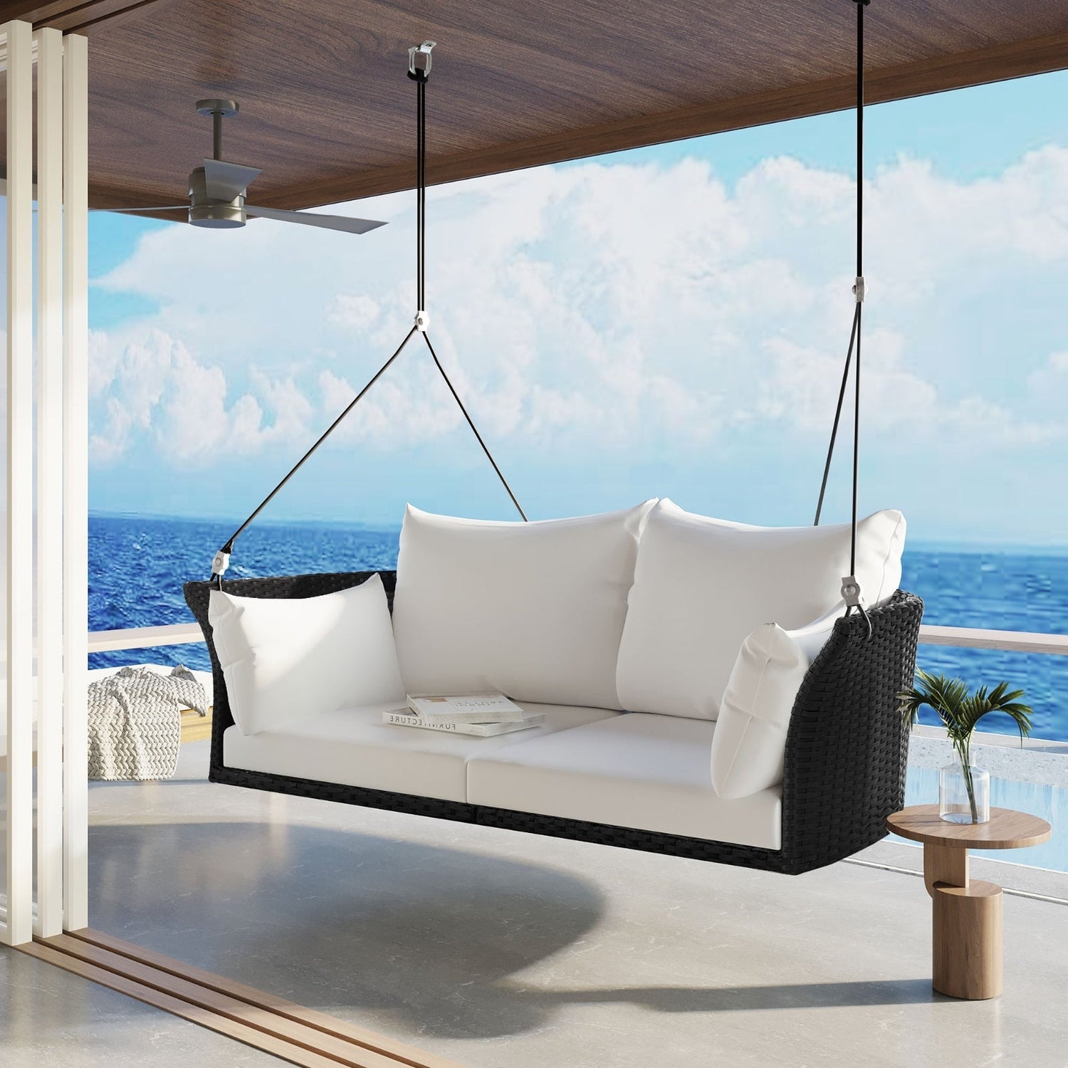 Black wicker hanging rattan porch swing for two from Carmine Juneberry, designed for garden outdoor relaxation.