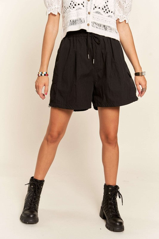 Jade Icarus ADORA drawstring shorts with pockets, automotive-inspired casual shorts, shown on a model with detailed fabric texture.