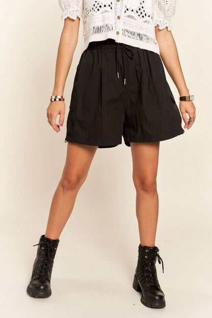Jade Icarus ADORA drawstring shorts with pockets, automotive-inspired casual shorts, shown on a model with detailed fabric texture.