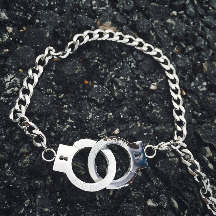 Fuchsia Molly handcuffs bracelet with metallic chain and lock detail, stylish accessory for edgy fashion statements.