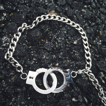 Fuchsia Molly handcuffs bracelet with metallic chain and lock detail, stylish accessory for edgy fashion statements.