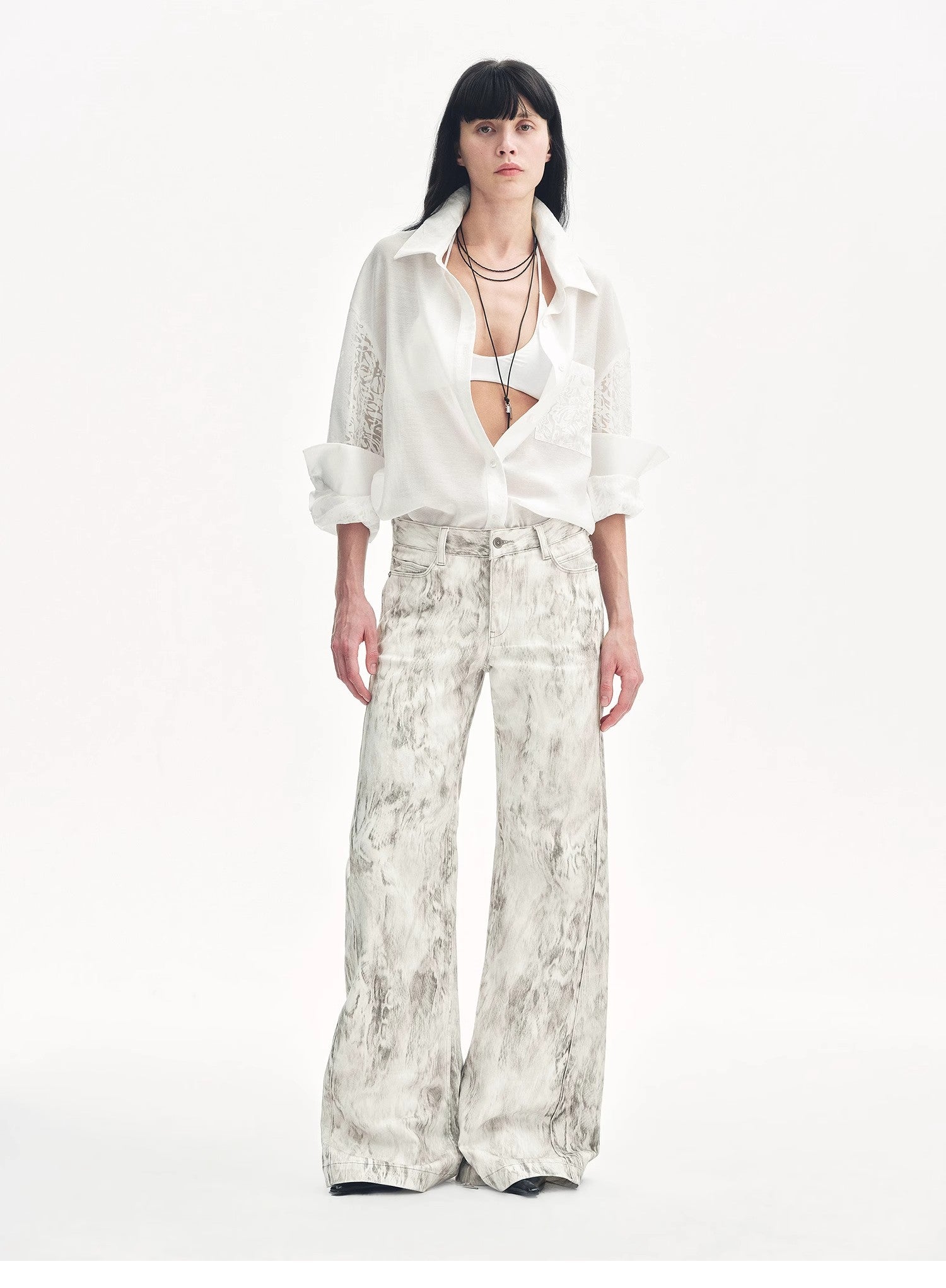 Brown Coeus "Phantom" snake print flared denim trousers, showcasing their unique snake pattern and stylish flare silhouette.