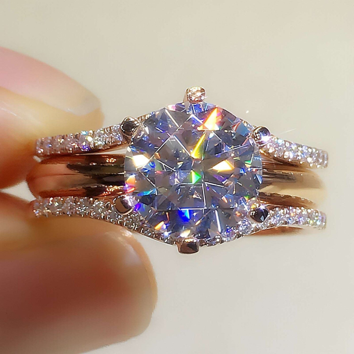 Pair of 18K gold moissanite rings from Carmine Juneberry, showcasing elegant design and sparkling gemstones.