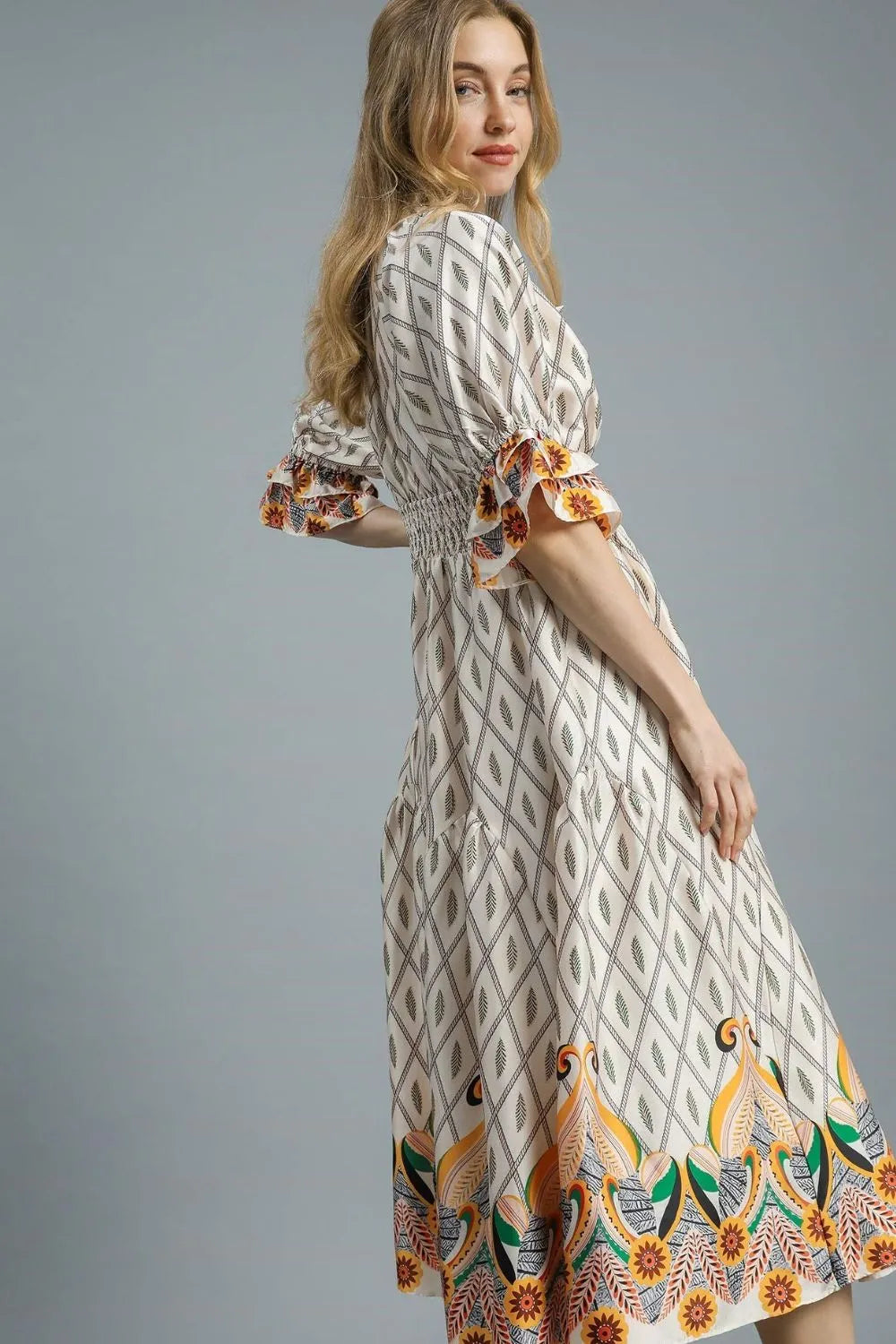 Pear Daisy Umgee printed smocked waist midi dress with flounce sleeves, showcased on a model in a home setting.