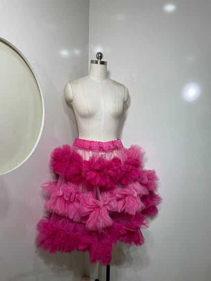 Pink tiered skirt for women by Champagne Pontus, featuring flowing fabric and layered design, perfect for casual or dressy occasions.
