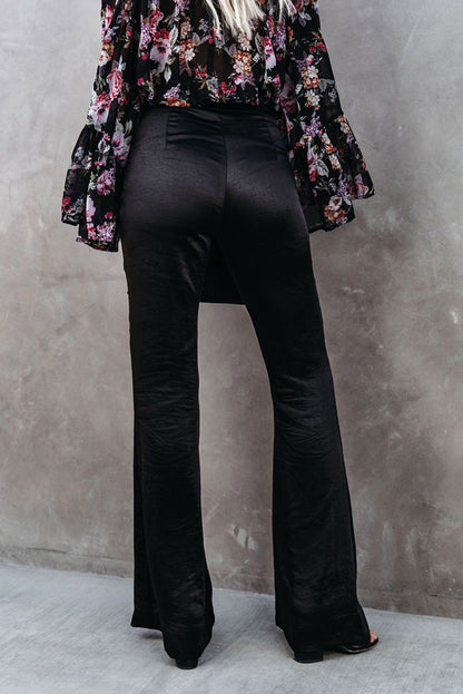 Black satin flare tailored pants by Harlequin Daisy, stylish and elegant bath and beauty clothing, shown on a model.