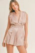 Pear Daisy MABLE draped romper with pleated shoulder pad detail, showcasing flowing fabric and stylish design in a home and garden setting.