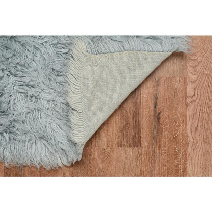 Light grey Flokati rug by Start2Finish, 5x8 feet with a soft, plush texture and 1400 grams weight, displayed on a floor.