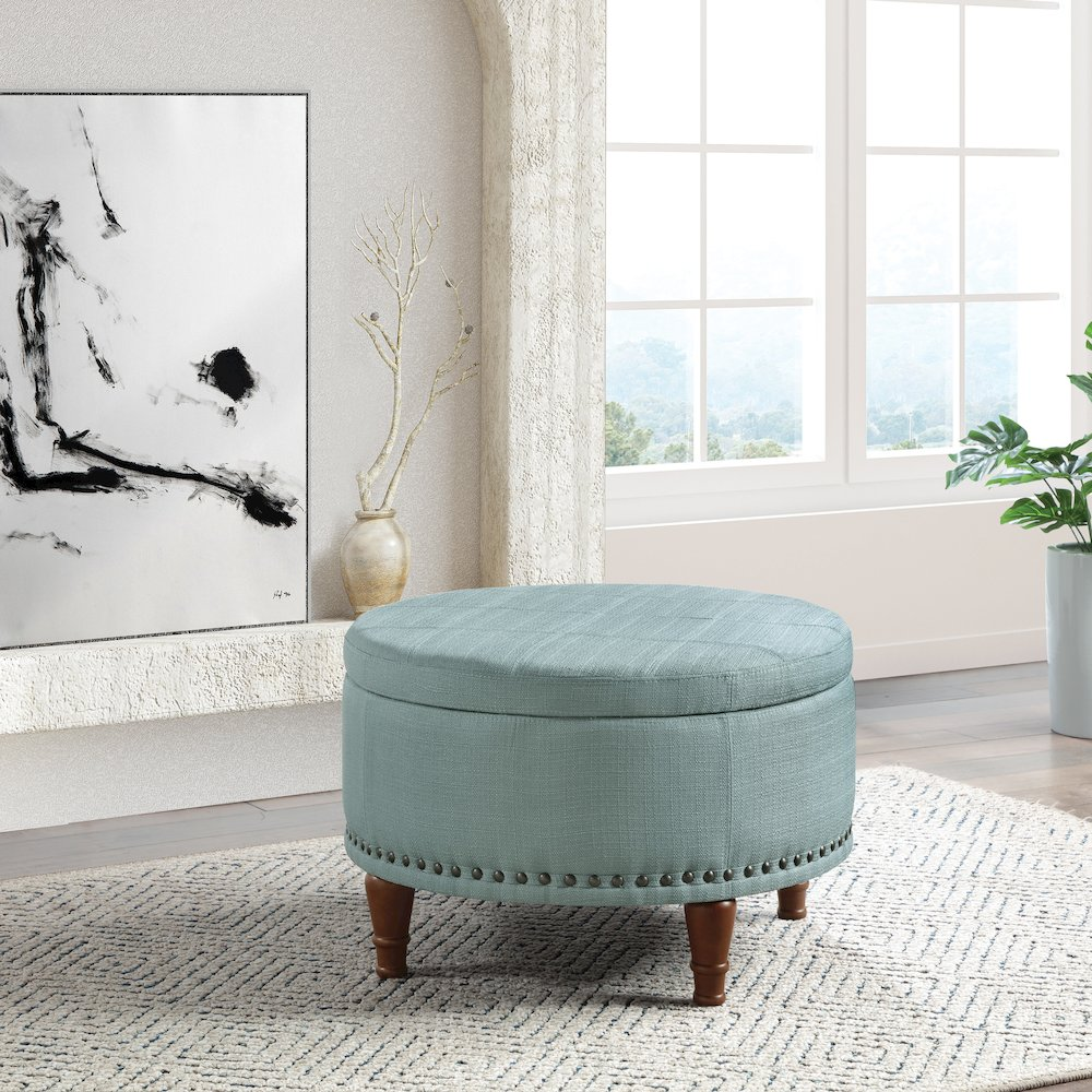 Start2Finish Alloway storage ottoman in sea blue fabric with antique bronze nailhead trim, showing its soft upholstery and decorative detailing.