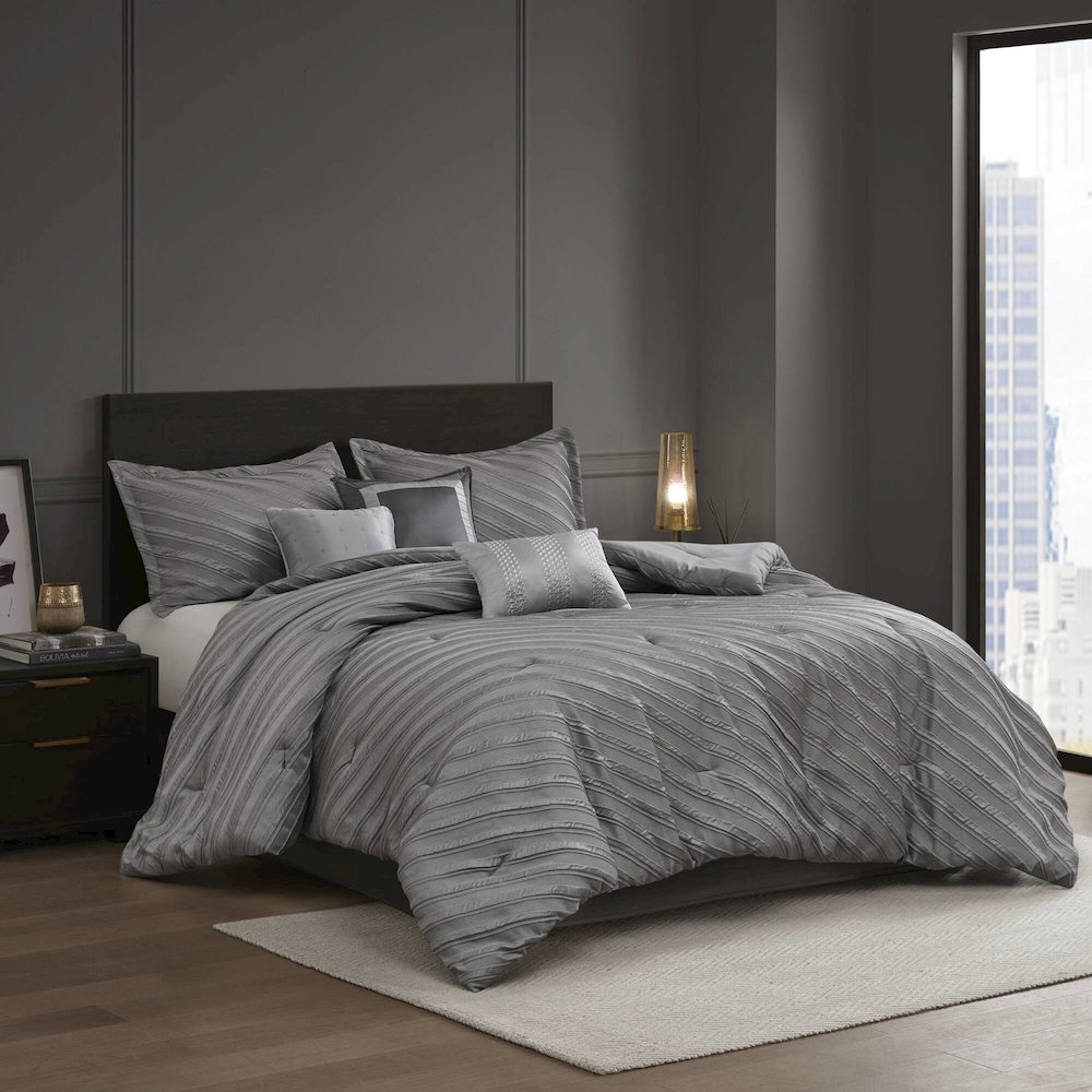 Start2Finish Riva 7-piece grey comforter set with matching pillow shams and decorative pillows on a bed.