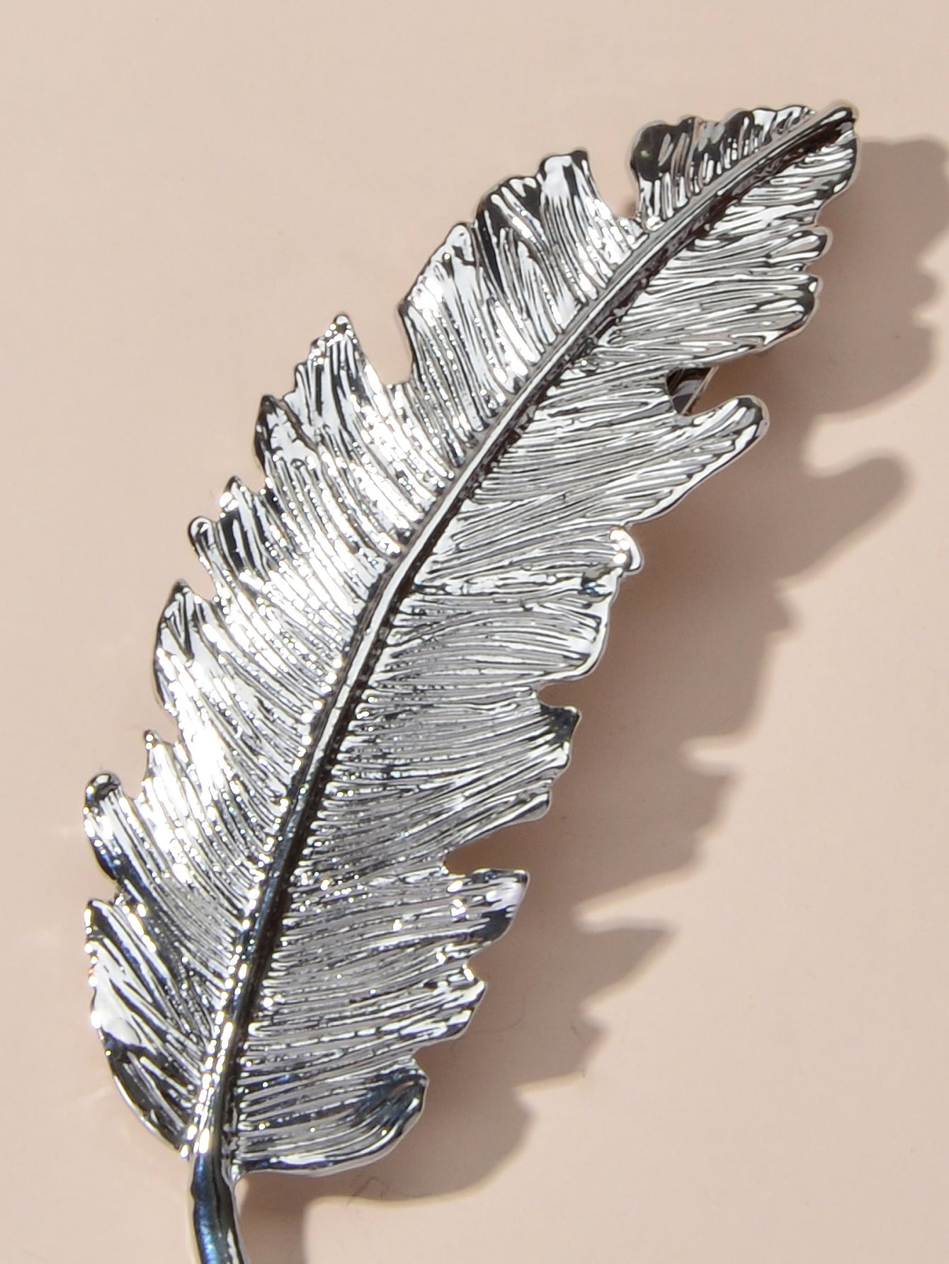 Gold and silver feather metal hair clips from White Demeter, stylish hair accessories with intricate feather design.