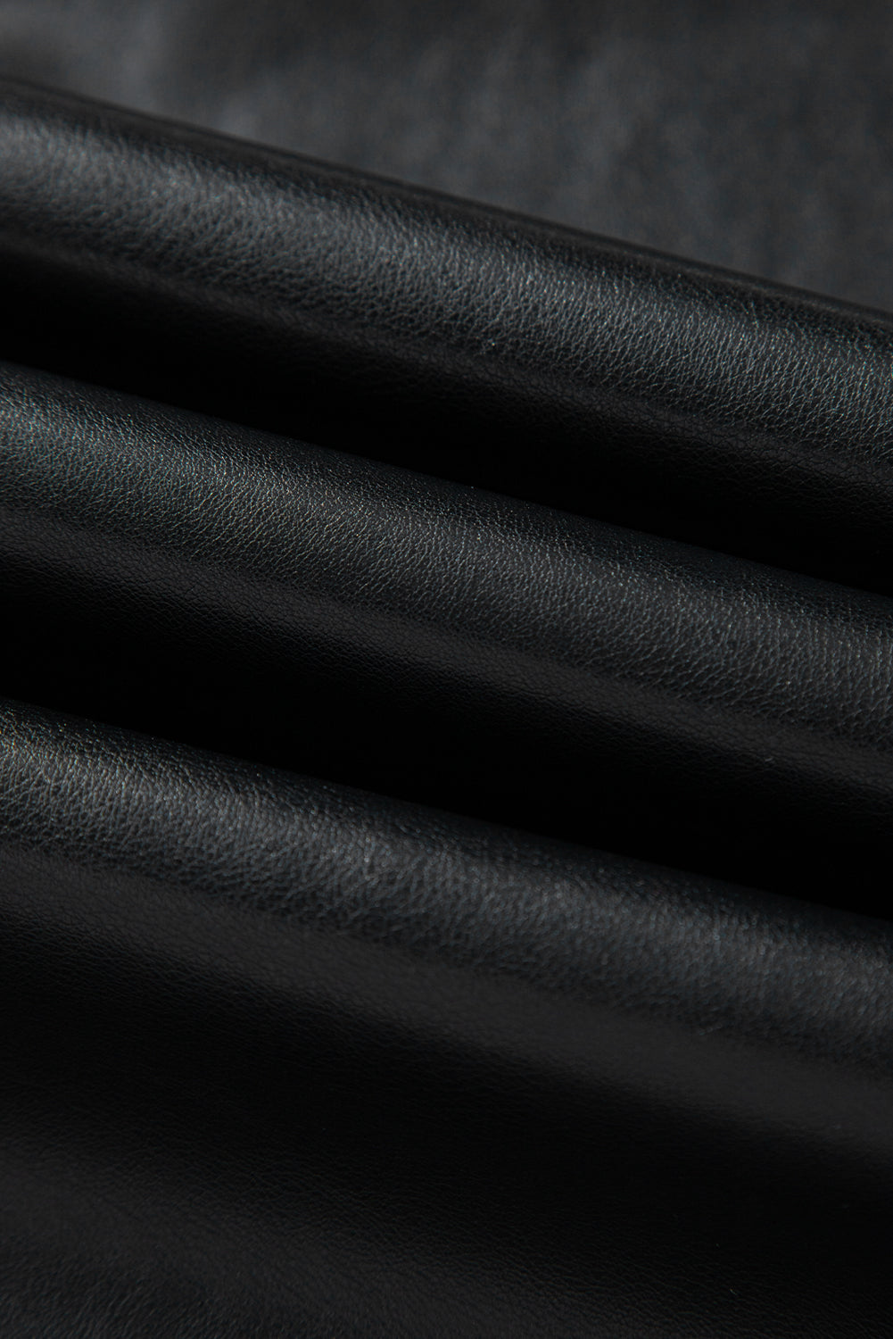Black solid faux leather side slit maxi skirt for women by Byzantium Bay, featuring a flowing design and side slit detail.