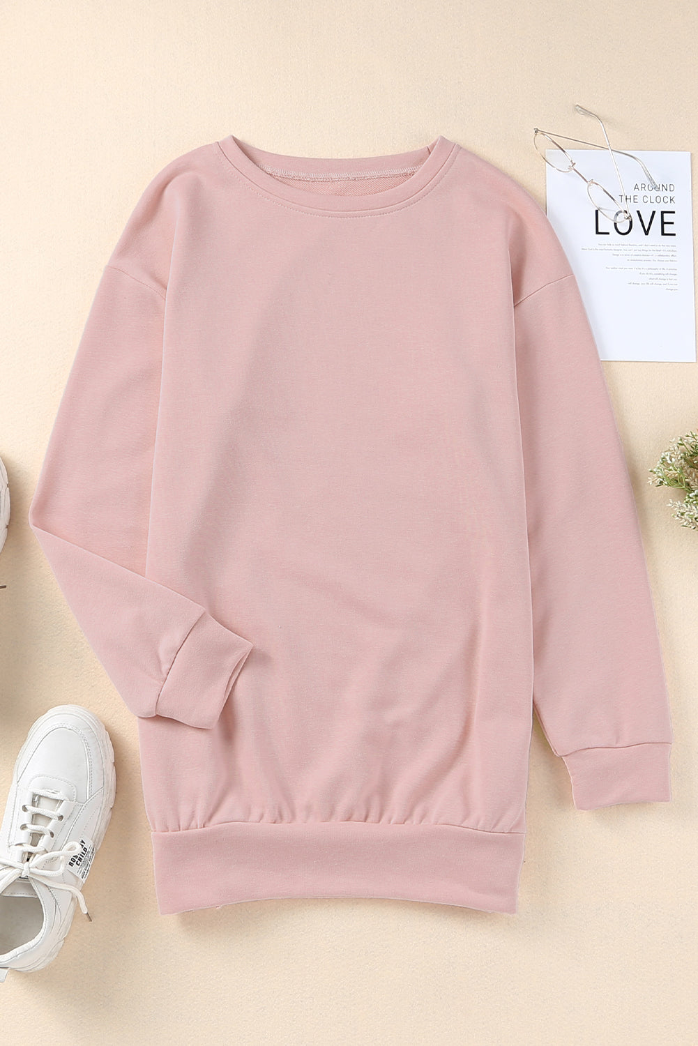Pink crew neck sweatshirt with slit buttons by Harlequin Daisy, casual bath and beauty apparel, shown on a hanger.