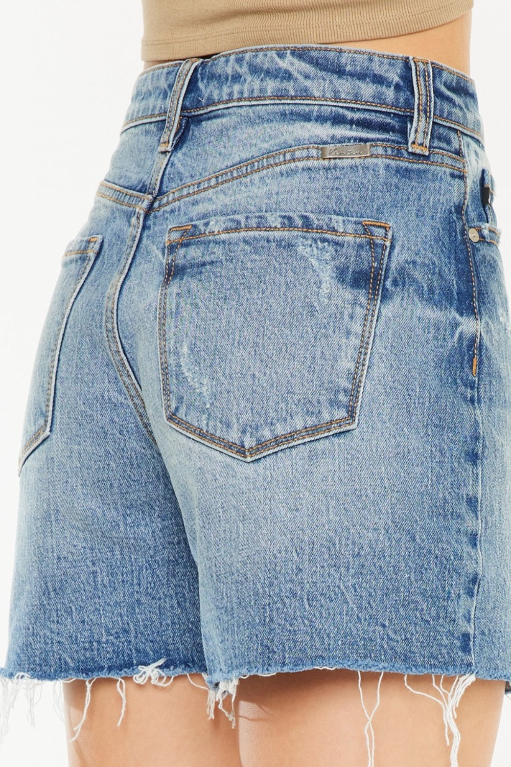 Jade Icarus Kancan high waist denim shorts with raw hem, showcasing distressed detailing and classic blue denim fabric.