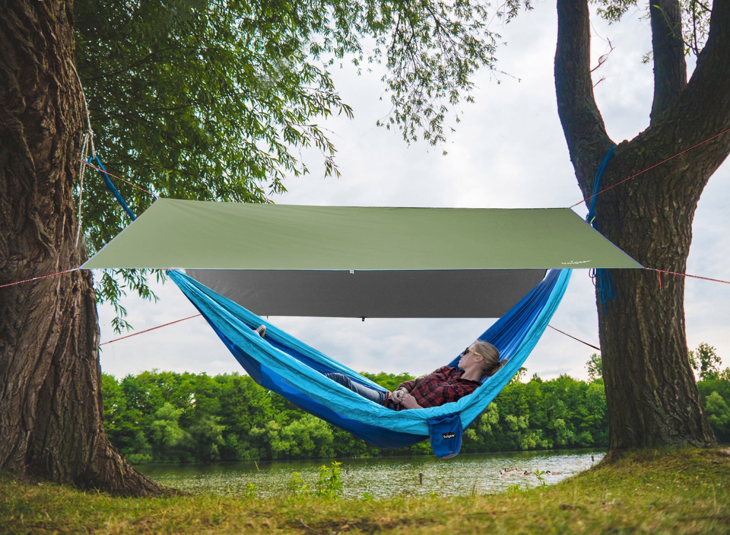 Indigo Eurybia rainproof camping tarp shelter set up outdoors, providing waterproof protection for camping or outdoor activities.