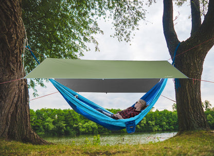 Indigo Eurybia rainproof camping tarp shelter set up outdoors, providing waterproof protection for camping or outdoor activities.