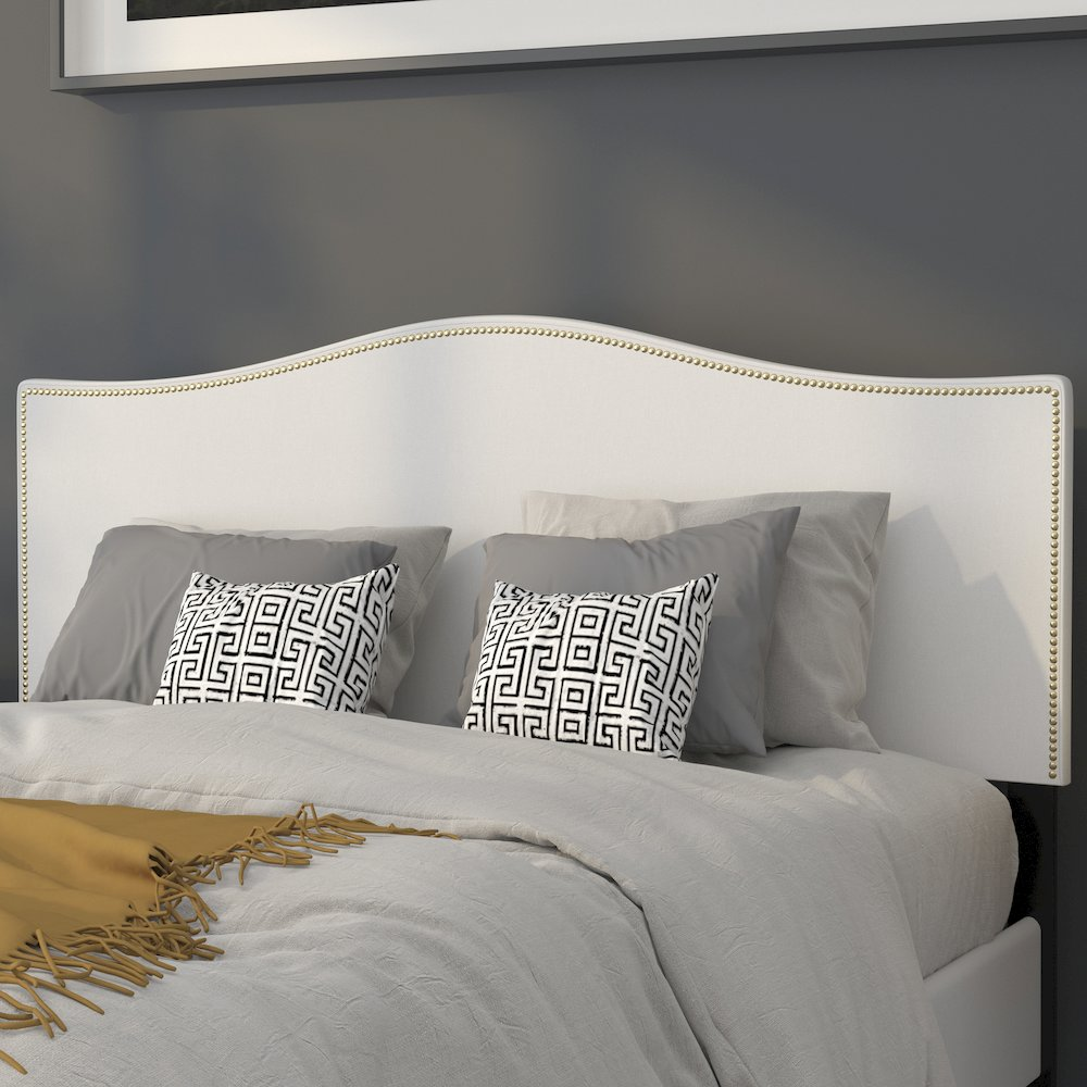 White fabric upholstered queen size headboard with accent nail trim, showcasing a stylish and modern furniture design.