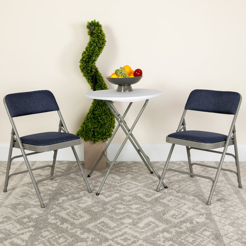 Two navy fabric HERCULES Series curved folding chairs with triple braced and double hinged metal frames, for versatile furniture use.