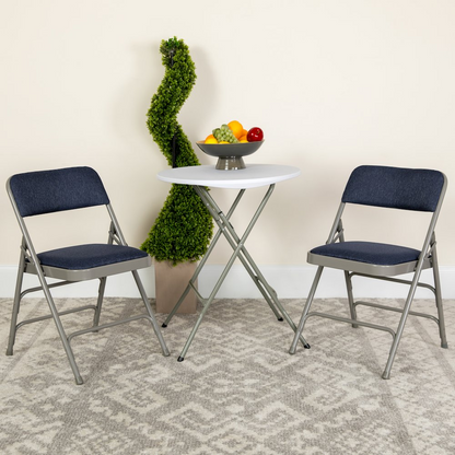 Two navy fabric HERCULES Series curved folding chairs with triple braced and double hinged metal frames, for versatile furniture use.