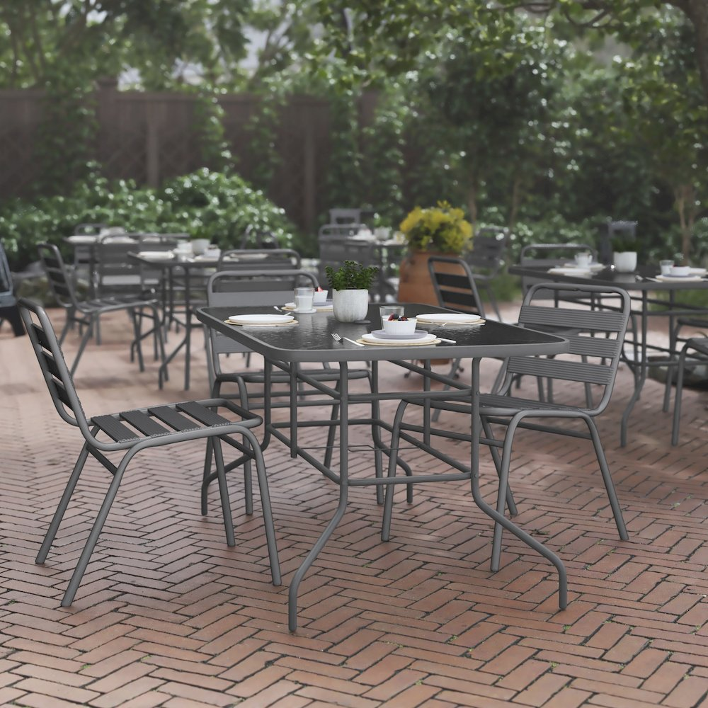 Rectangular glass patio table with seating for six, featuring a sturdy metal frame and clear glass surface for outdoor dining.