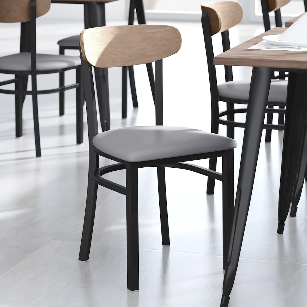 Start2Finish commercial dining chair with vinyl upholstered seat and wood boomerang back, shown in a modern restaurant setting.