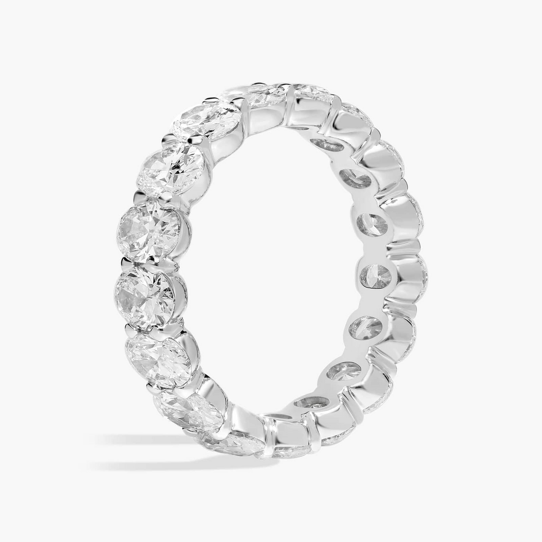 Created moissanite oval eternity band ring in 14k white gold overlay with sparkling gemstones encircling the entire ring.