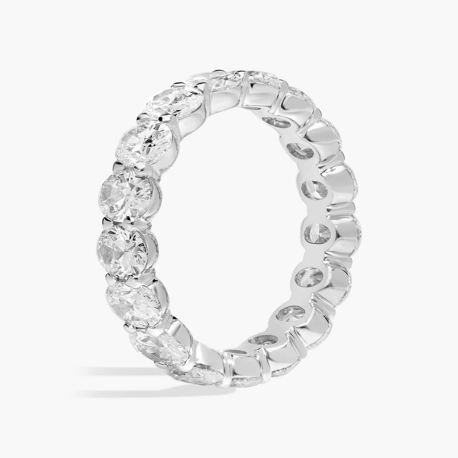 Created moissanite oval eternity band ring in 14k white gold overlay with sparkling gemstones encircling the entire ring.