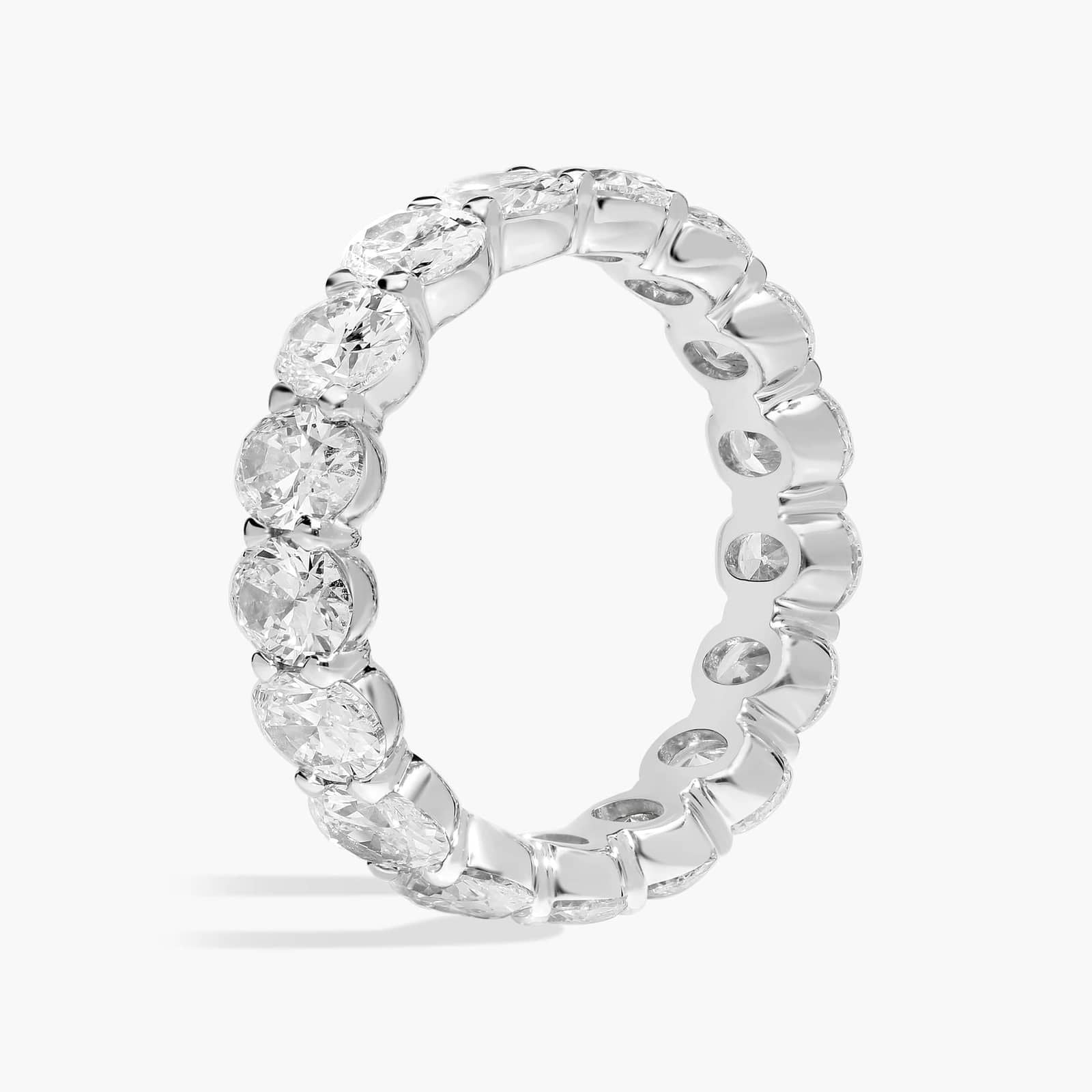 Created moissanite oval eternity band ring in 14k white gold overlay with sparkling gemstones encircling the entire ring.