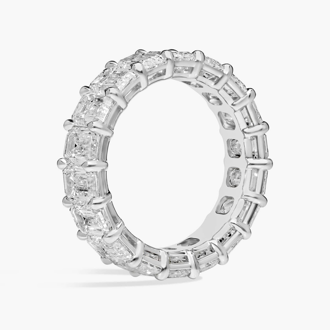 Created Moissanite eternity band ring with 5.00 CTW emerald cut stones in 14k white gold overlay, showcasing sparkling gemstones.