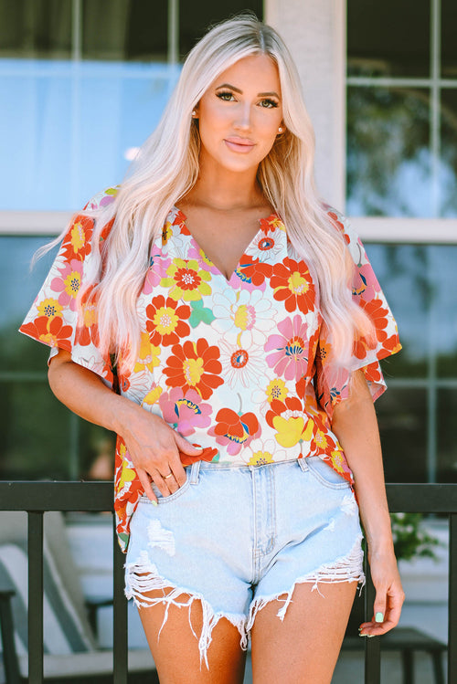 Orange abstract print V-neck half sleeve blouse by Carmine Juneberry, showing the stylish design and vibrant fabric details.