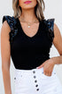 Solid ribbed leatherette bodysuit with ruffle sleeves by Byzantium Bay, featuring a fitted design and textured fabric.