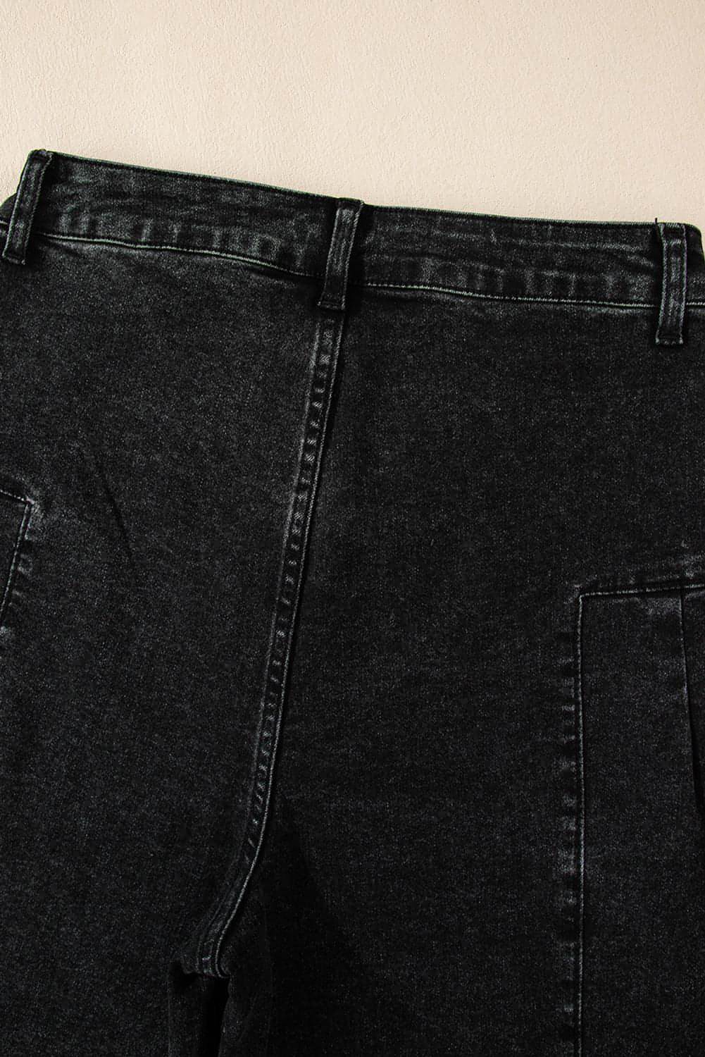 Dark grey pleated wide-leg denim pants by Carmine Juneberry with mineral wash finish, showcased on a model.