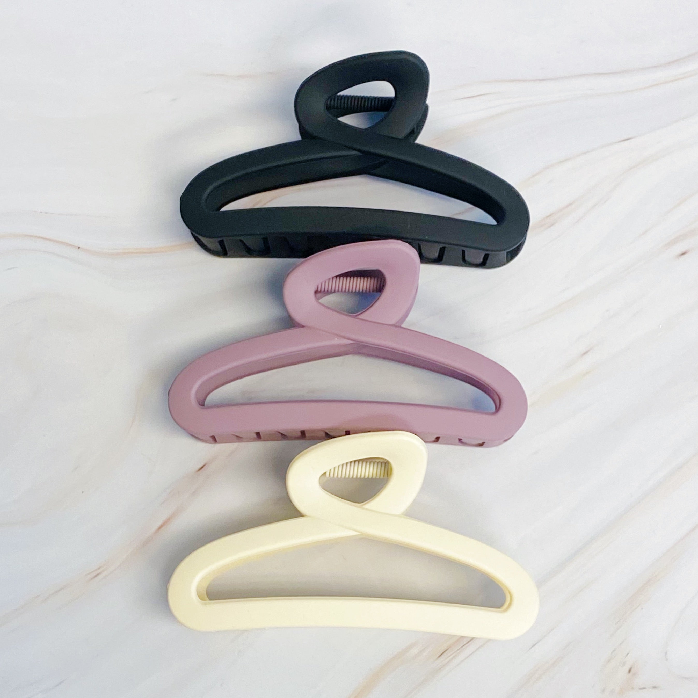Set of three Fuchsia Hercules hair claw clips with stylish jewelry-inspired designs, perfect for securing hair comfortably.