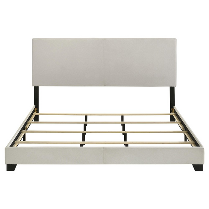 Cream fabric upholstered Eastern King panel bed with sleek design and wooden accents, featuring a high headboard and sturdy frame.