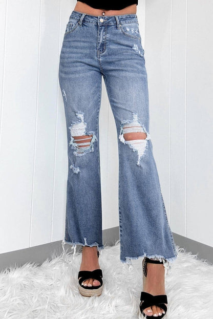 Dusk blue high-rise flared jeans by Carmine Juneberry with ripped distressed hems and a stylish fit.
