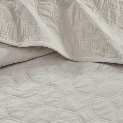 Start2Finish Harper 3-piece velvet quilt set in ivory, including a quilt and matching pillow shams, displayed on a bed.