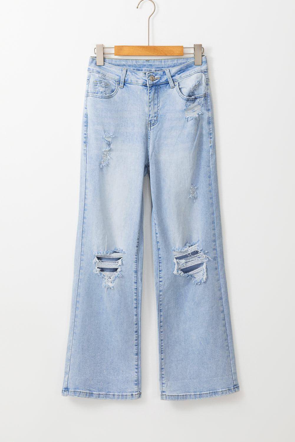 Carmine Juneberry Beau Blue vintage light wash distressed flare jeans with frayed hems and faded detailing on a model.