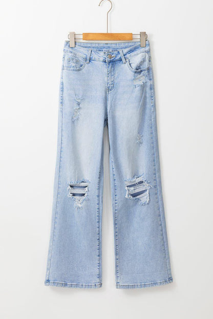 Carmine Juneberry Beau Blue vintage light wash distressed flare jeans with frayed hems and faded detailing on a model.