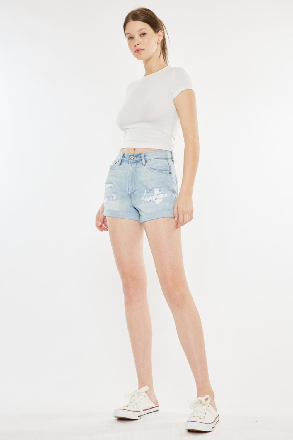Jade Icarus Kancan high rise repaired mom denim shorts, stylish distressed denim with frayed hems, laid flat on a white background.