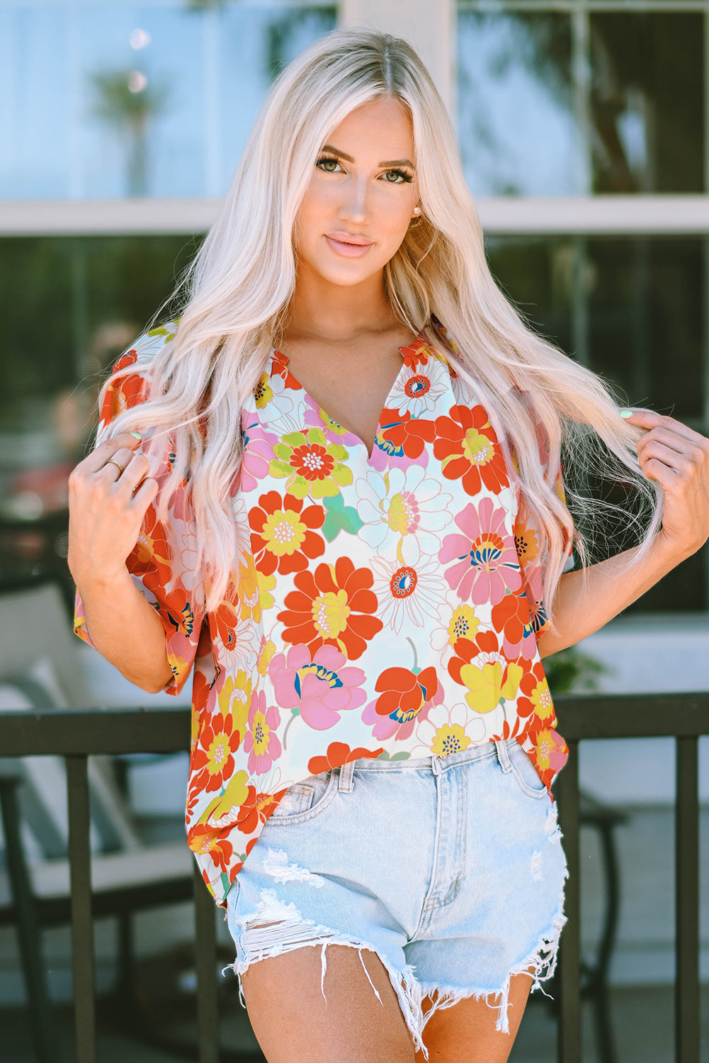 Orange abstract print V-neck blouse with half sleeves from Carmine Juneberry, stylish top in a vibrant, artistic design.